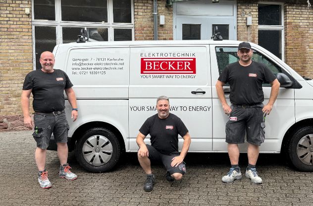 Guiseppe mit Mitarbeitern vor dem Becker Elektrotechnik Firmenwagen